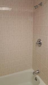 łazienka z prysznicem i białą wanną w obiekcie The Amethyst Beach Motel w mieście Point Pleasant Beach