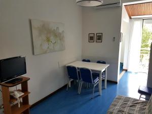 a room with a table and chairs and a television at Hotel Residence Adriana in Cesenatico