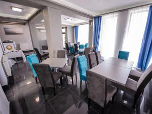 a dining room with tables and chairs and windows at Vila La Mer Mamaia Nord in Mamaia Nord