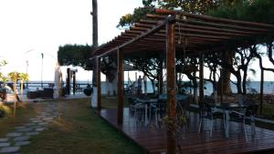 Ilha dos Corais في Gamboa: سطح خشبي مع طاولات وكراسي على الشاطئ