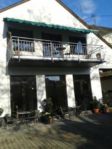 a building with a balcony and tables and chairs at Ferienhaus Schenden in Piesport