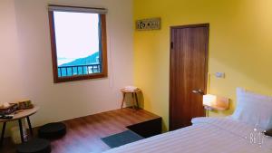 a bedroom with a bed and a window and a table at 雲在山房 in Jiufen