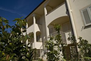 a white building with a balcony and plants at Villetta Tina in Vada