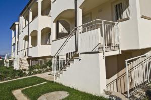 a white building with stairs and grass at Villetta Tina in Vada
