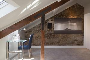 a dining room with a table and a brick wall at Giles Norman Gallery & Townhouse in Kinsale