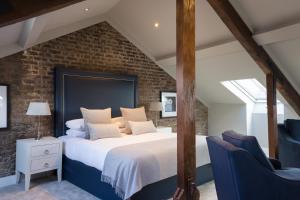 una camera con un grande letto e due sedie blu di Giles Norman Gallery & Townhouse a Kinsale