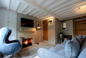 Walnut Cottage في موريتون إن مارش: غرفة معيشة مع أريكة ومدفأة