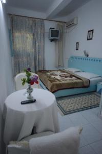 a room with a bed and a table with a vase of flowers at Houria House Sable D'or in Mahdia