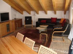 a living room with a couch and a table and chairs at Apartment Amore in Riederalp