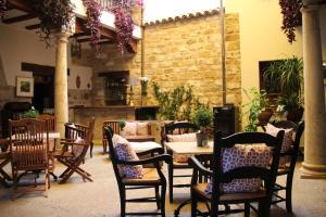a restaurant with tables and chairs and a brick wall at Alvaro de Torres Boutique in Úbeda