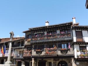 a tall building with balconies and flowers on it at VillaDolores in La Alberca