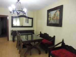 uma sala de jantar com uma mesa, cadeiras e um espelho em VillaDolores em La Alberca