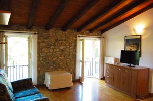 a living room with a couch and a tv at Apartment Casa Caterina in Gargnano