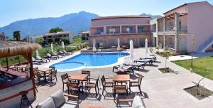 a resort with a swimming pool and tables and chairs at Issalos Studios in Skala Potamias