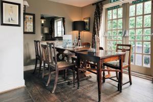 a dining room with a wooden table and chairs at Rose And Crown in Porthcawl