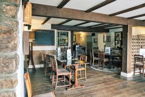 a dining room with tables and chairs and a chalkboard at Rose And Crown in Porthcawl