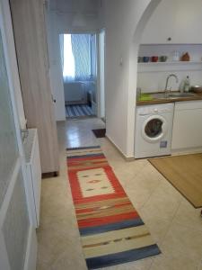 佩奇的住宿－Vince apartman，厨房配有洗衣机和色彩缤纷的地毯。
