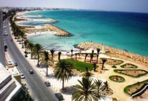 een uitzicht op een strand met palmbomen en de oceaan bij Houria House Sable D'or in Mahdia