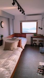 a bedroom with a bed and a table and a window at 雲在山房 in Jiufen