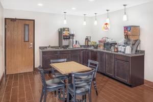 a kitchen with a table and chairs and a counter at Super 8 by Wyndham Marshall in Marshall