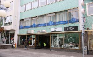 a building on a street with people walking in front of it at Hafnarstræti Hostel in Akureyri