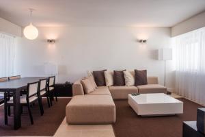 a living room with a couch and a table at Troia Residence by The Editory - Apartamentos Marina in Troia