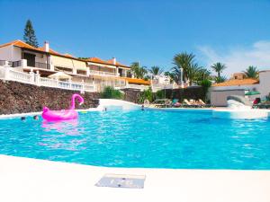 a swimming pool with a pink swan in the water at Apartment in Paraiso Royal in Playa de las Americas