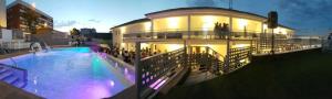 a large building with a swimming pool in front of it at Deluxe Hostels & Suites Merida in Mérida