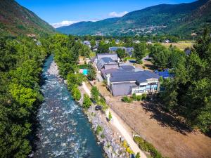 - une vue aérienne sur une maison à côté d'une rivière dans l'établissement Village Vacances Passion L'Estibère, à Vielle-Aure