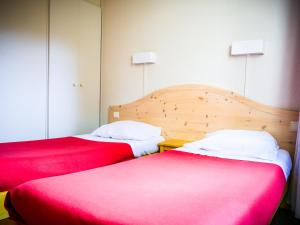 Vielle-AureにあるVillage Vacances Passion L'Estibèreのベッド2台が隣同士に設置された部屋です。