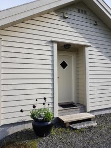 a white house with a door with a window at Ropeid Fjordferie in Ropeid