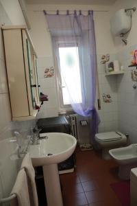 bagno con lavandino, servizi igienici e finestra di Laura's Apartment Vatican a Roma