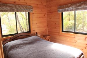 1 dormitorio con 1 cama en una cabaña de madera en Refugio Altazor, en Las Trancas