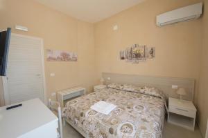 Dormitorio pequeño con cama y TV en Vela Latina Affittacamere, en Marsala