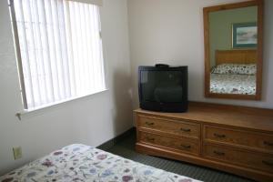 un televisor sentado en un tocador en un dormitorio en Affordable Suites Salisbury en Salisbury