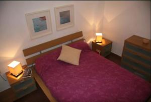 a bedroom with a purple bed with two night stands at Marenostrum view in Playa Pobla de Farnals +11 photos