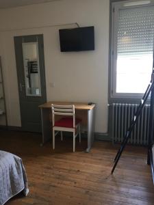 ヴァランスにあるHotel Relais Sudのテーブル、椅子、テレビが備わる客室です。
