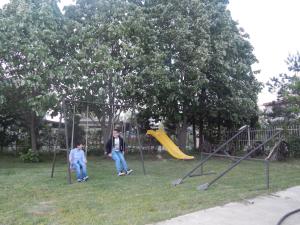 Dois homens sentados num baloiço num parque. em Hotel Restoran Antika em Strumica