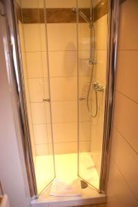 eine Dusche im Bad mit einer Duschkabine aus Glas in der Unterkunft Hotel Stadt Soest in Soest