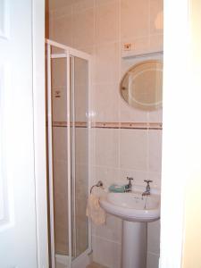 a bathroom with a sink and a shower at Findus House, Farmhouse Bed & Breakfast in Macroom