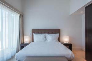 a bedroom with a large bed with two lamps on tables at Troia Residence by The Editory - Apartamentos Marina in Troia