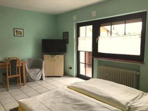 - une chambre avec un lit, une télévision et une chaise dans l'établissement Hotel Restaurant Alt Laubach, à Laubach