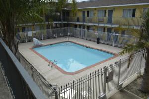 a large swimming pool with a fence around it at Americas Best Value Inn and Suites Groves in Groves