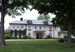 a large white house with a lawn and trees at The Belvedere Inn & Restaurant in Saugatuck