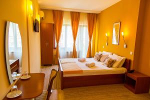 Habitación de hotel con cama, escritorio y mesa. en Hotel Pine en Skopie