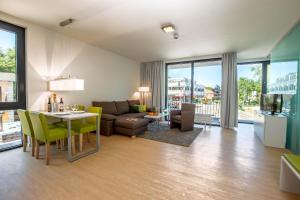 a living room with a couch and a table at Carat Apartments Grömitz in Grömitz