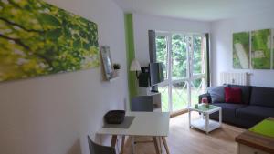 ein Wohnzimmer mit einem Sofa und einem Tisch in der Unterkunft Appartement Schultz - Grüne Aue in Braunlage