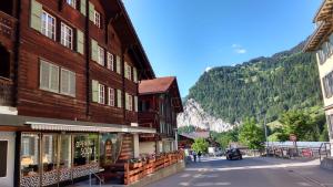 a street in a town with buildings and a mountain at BASE Cafe in Lauterbrunnen