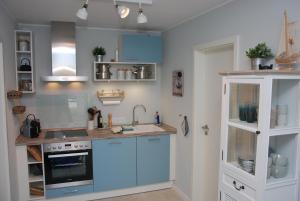 a kitchen with blue cabinets and a sink at Meine ECKE 2 in Eckernförde