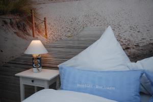 a bed with a lamp on a table next to a beach at Meine ECKE 2 in Eckernförde